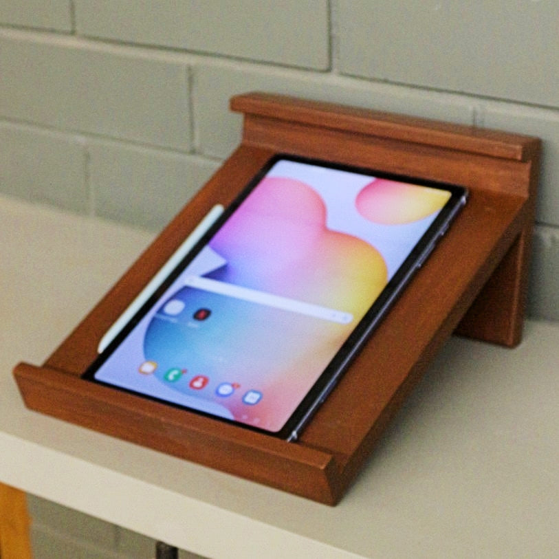 <img src="tablet-stand.jpg" alt="Tablet stand from Barish Home Decor, designed to hold tablets securely with a sleek and sturdy wooden frame.">