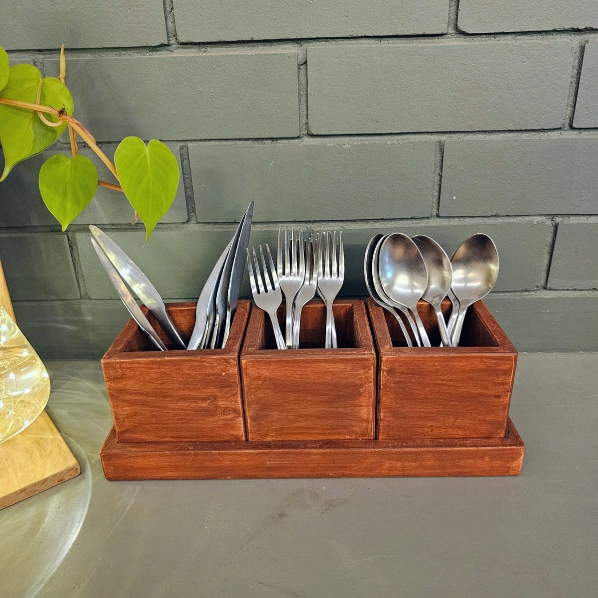 <img src="cutlery-holder.jpg" alt="Wooden cutlery holder with 3 compartments, designed for organizing spoons, knives, and forks on the dining table.">
